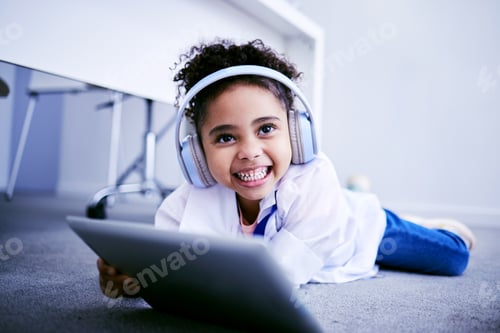 Preview: Tablet, headphones and education with a student girl lying on the floor on her home for distance le