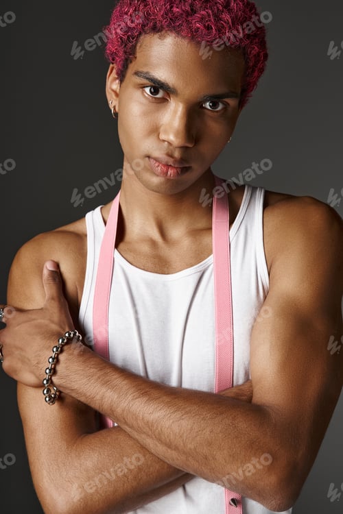 Preview: portrait of young stylish man with pink hair posing with slightly crossed arms, fashion concept