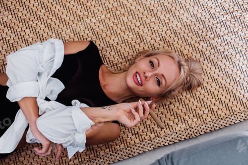 Preview: Portrait of sexy blonde woman in body suit and white shirt with pink beautiful lips holding cigar