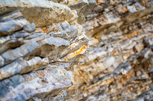Preview: Layered rock texture in Budva, Montenegro. Sedimentary rocks with rugged surface of gray and brown