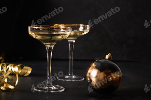 Visualização: Taças festivas de champanhe de Ano Novo e enfeites dourados de Natal.