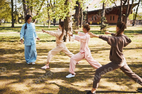Preview: Tai chi instructor checking the postures of her students