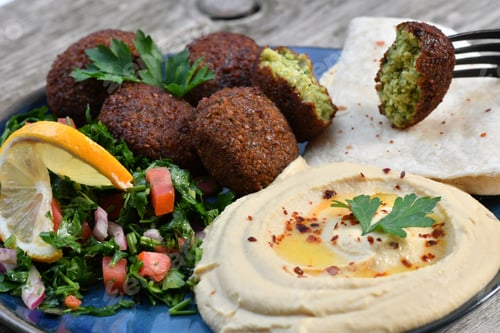 Preview: Closeup shot of traditional homemade falafel with different vegetables and hummus