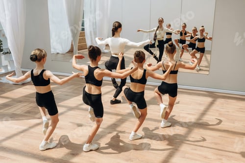 Preview: Looking at the mirror. Trainer is teaching girls ballet dancing