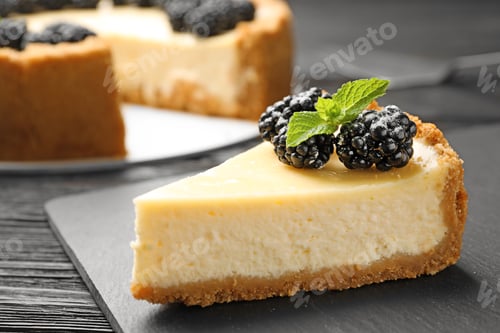 Preview: Piece of delicious cheesecake decorated with blackberries on table