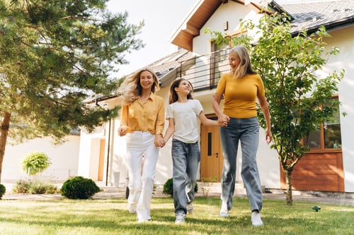 Preview: Happy family walking together in front of house beautiful mother grandmother and little girl