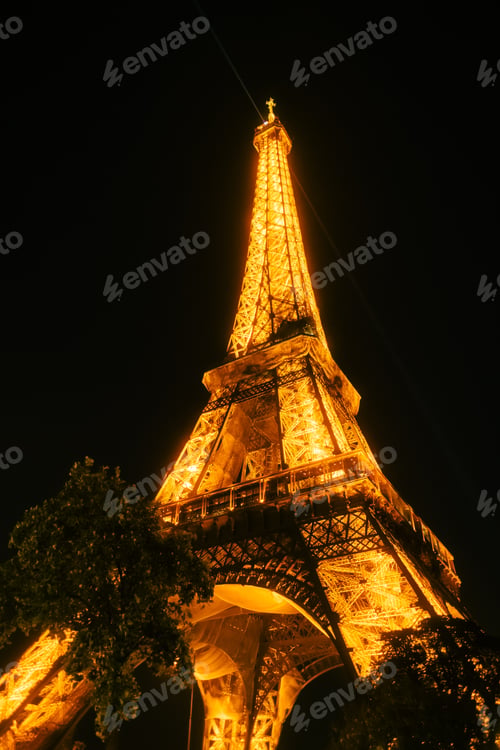 Preview: Glowing Eiffel Tower against the sunset sky in Paris, France.