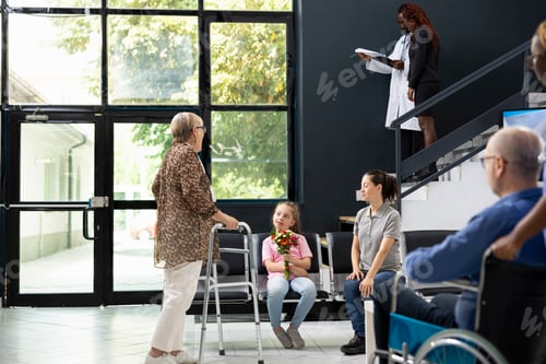 Preview: Little child handing flowers bouquet to grandmother with walking frame
