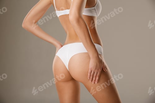Vista previa: Mujer pellizcándose la piel de las caderas probando la capa de grasa corporal subcutánea