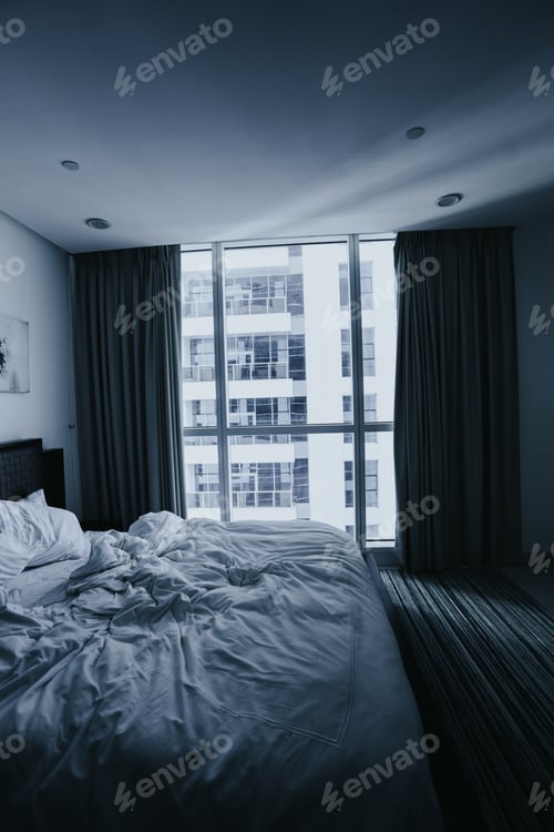 Preview: Vertical shot of a messy bed in a tall building captured in the daytime