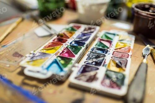 Preview: poster paints and watercolor paints on wooden table in workshop