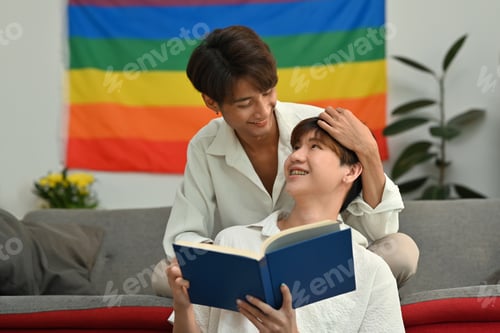 Preview: Serene homosexual couple reading book, spending time together on weekend.