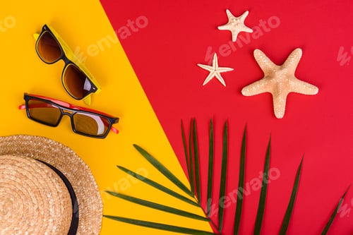 Preview: Beach accessories: glasses and hat with shells and sea stars on a colored background
