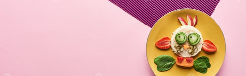 Preview: top view of plate with fancy cow made of food on pink and purple background