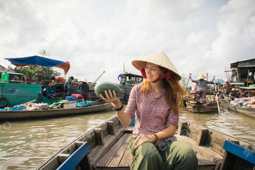 Preview: Woman tourist buying fruits from the boat on Cai Rang floating market, Can Tho, Vietnam