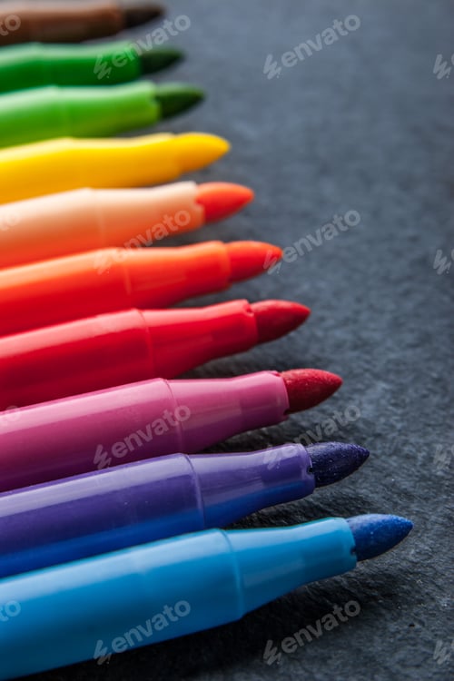 Preview: Colorful felt pens on the dark stone background vertical