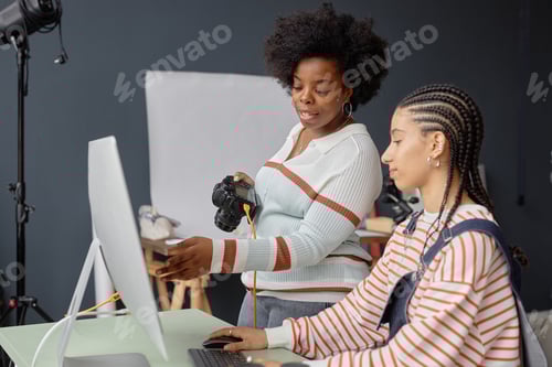 Preview: Female Photographers Collaborating in Photo Studio