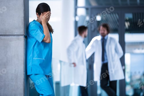 Preview: Stressed nurse standing in hospital