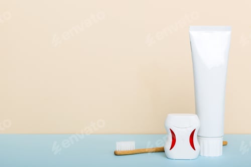 Preview: toothpaste and toothbrush top view with copy space on colored background.