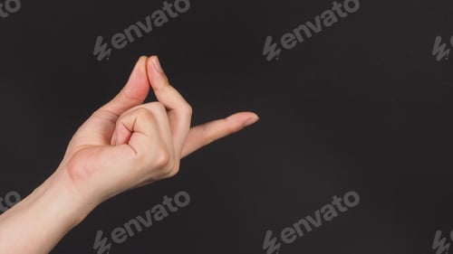 Preview: Male model is doing snap gesture with left hand sign on black background.