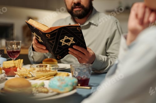 Preview: Cropped shot of bearded man with open Torah reading Psalms or other text