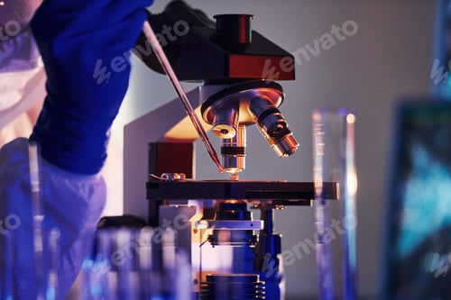 Preview: Scientist in white protective uniform works with coronavirus and blood tubes in laboratory
