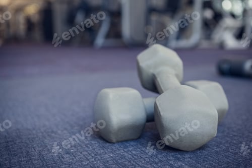 Preview: Grey dumbbells on the weights room floor at the gym