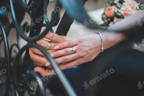 Preview: Closeup shot of a bride and groom showing their rings