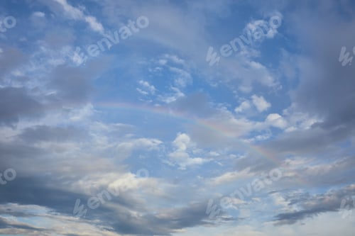 Preview: view of rainbow on blue sky background and blue clouds