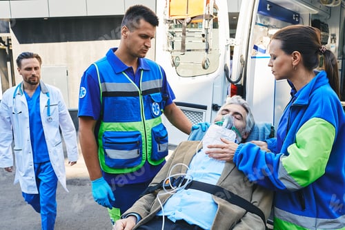 Preview: Doctor rushing to senior patient with breathing mask on ambulance stretcher who was brought by