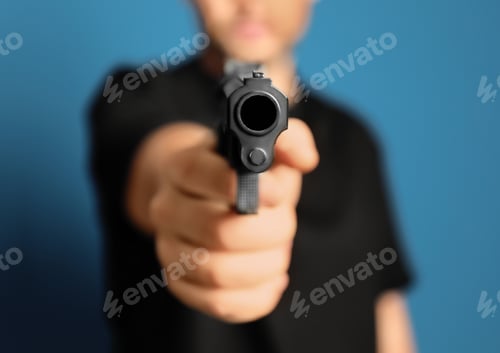 Preview: Man holding gun on blue background, closeup