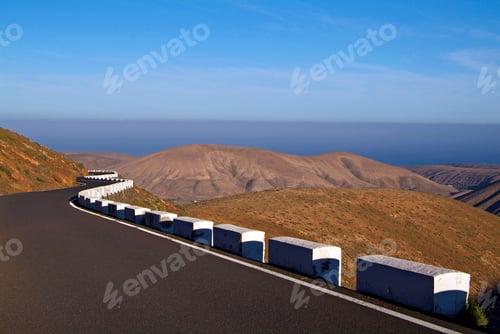 Preview: Winding road through a serene hilly landscape