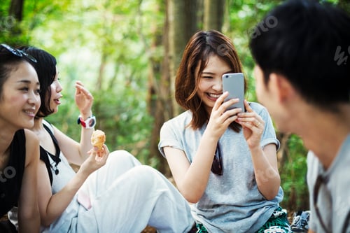 Preview: Three young women and a man sitting in a forest.