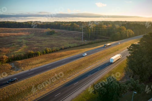 Preview: Aerial view of busy american highway with fast moving traffic surrounded by fall forest