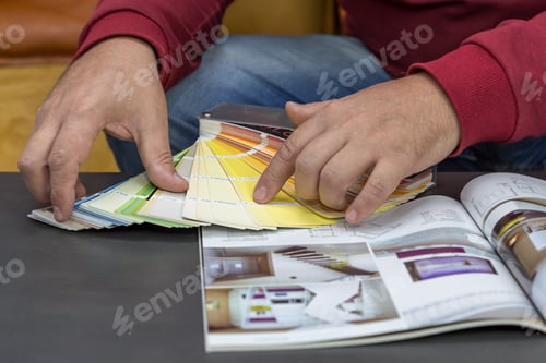 A man chooses a color according to the Pantone palette for apartment renovation