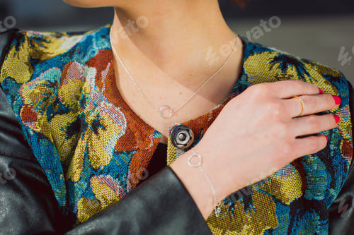 Preview: A fashionable woman poses confidently, showcasing elegant jewelry with a floral outfit while