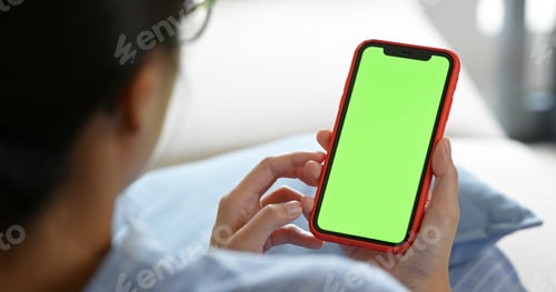 Preview: Woman use of mobile phone in green screen at home