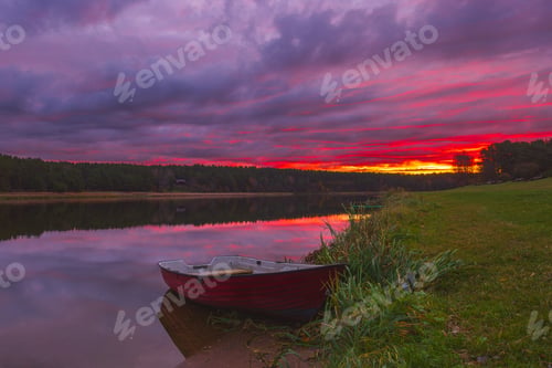 Preview: A Serene Sunset Over Calm Waters Featuring a Charming Green Boat Floating Gracefully. Birstonas