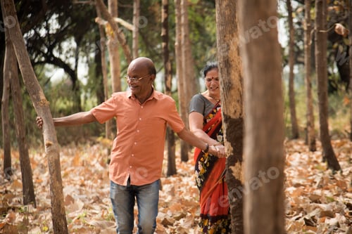 Preview: Happy Indian senior couple walking in forest