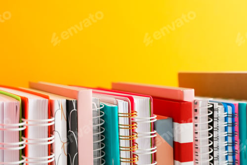 Preview: Stack of colorful books against background, space for text
