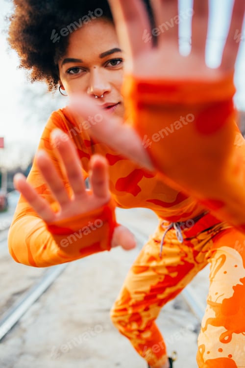 Preview: Young mixed race curly hair woman dancing outdoor