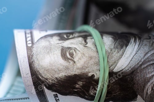 Preview: close up macro of paper currency roll of hundred dollars knitted by rubber band