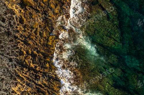 Preview: Blue ocean water and waves crash on the beach, drone view