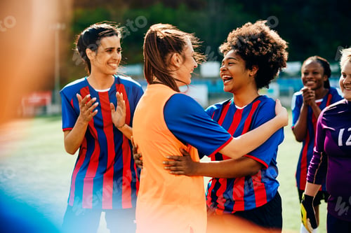 Preview: Women's soccer team having fun after successful game on playing field.