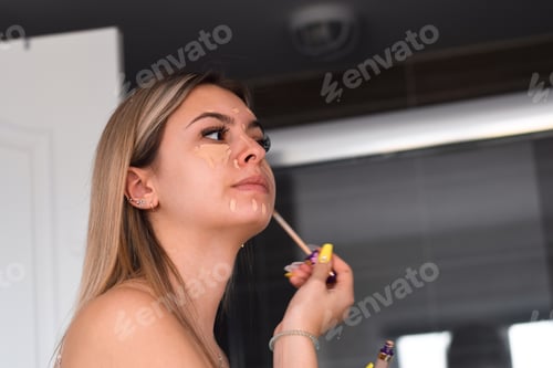 Preview: Young woman, teenage girl is applying make up in a bathroom, getting ready to go out