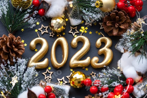 Preview: The golden figures 2023 made of candles on a black stone slate background