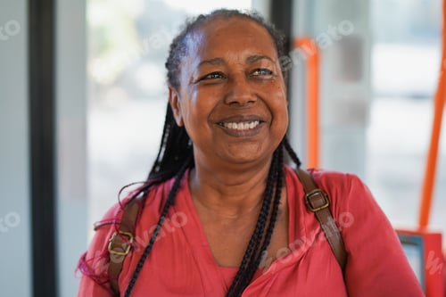 Preview: Happy senior african woman smiling on camera inside bus