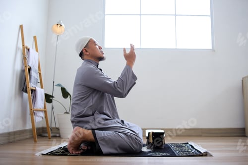 Preview: Portrait Of Young Asian Muslim Guy Praying With Raising Hands And Closed Eyes
