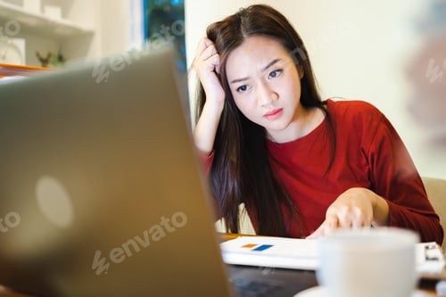 Preview: Woman working overtime in office sitting at desk late at night doing paperwork and reading report