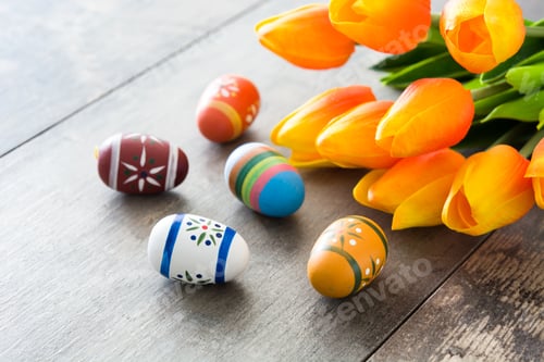 Preview: Easter eggs and orange tulips creating festive atmosphere on wooden table